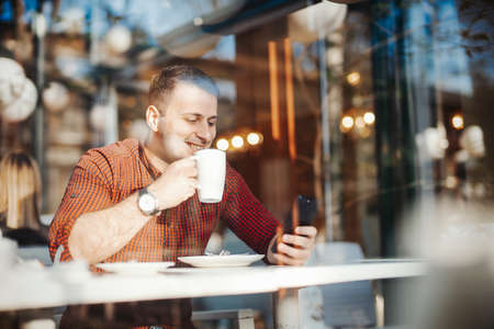 Young attractive man drinking coffee at lunch timeの写真素材
