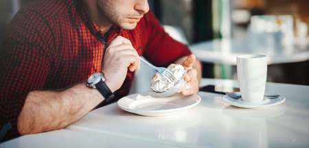 Young attractive man drinking coffee at lunch timeの写真素材