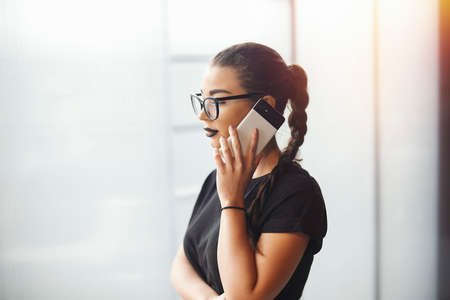 Young brunette girl talking by mobile phoneの写真素材