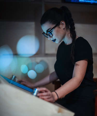 Young brunette girl student with glasses and black lipstick reading Ebook in the universityの写真素材