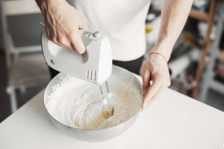 Young cook mixes dough