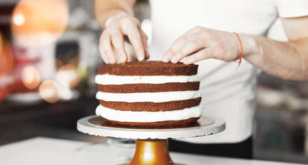 Young attractive man decorating cake