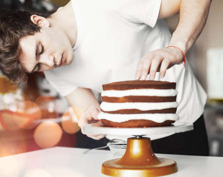 Young attractive man baking cakeの写真素材