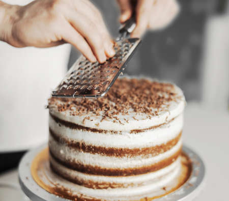 Young attractive man decorating cakeの写真素材