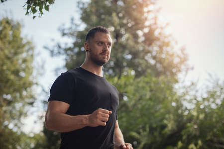 Young man running outdoors in the park.の写真素材