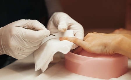 Close up Manicurist Pushing Cuticles On Female Nails With Stick For Cuticle.の写真素材