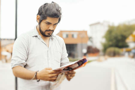 Attractive pensive brunette latin man looking at the map.の写真素材