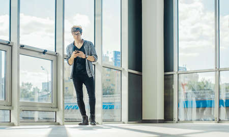 Distant plan of young man listening to music at the railway station.の写真素材