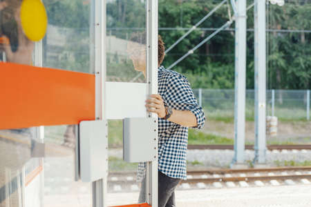 Distant plan of young attractive man opening door in metro station.の写真素材