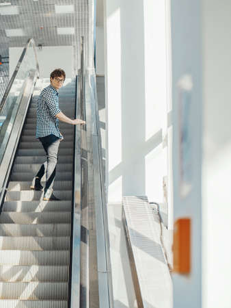 Distant plan of young attractive man escalating in metro station.の写真素材