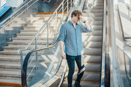 Distant plan of young attractive man escalating in metro station.の写真素材