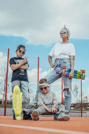 Young woman standing with her sons at playground. Happy family concept.の写真素材