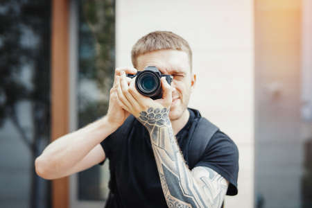 Close up of attractive man making photos at cityscape backgroundの写真素材