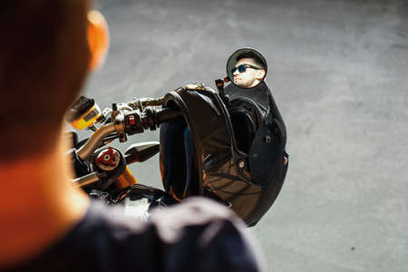 Close up of handsome biker sitting on motorcycle and reflecting in side view mirror.の写真素材