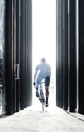 Sport bike man riding inside urban glass tunnel with light.の写真素材