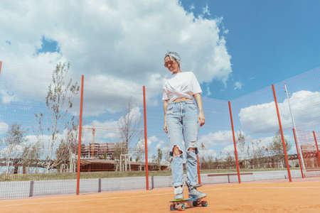 Young woman sitting with her sons at playground. Happy family concept. Family is on focus and foreground, playground is blurred.の写真素材