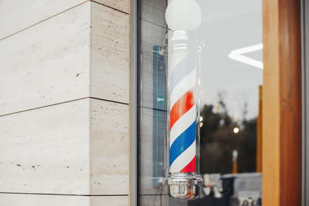 Close up of hairdressing saloon vintage barber pole in barbershop showcase.の写真素材