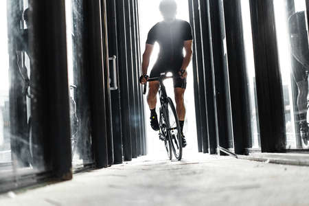 Sport bike man riding inside urban glass tunnel with light.