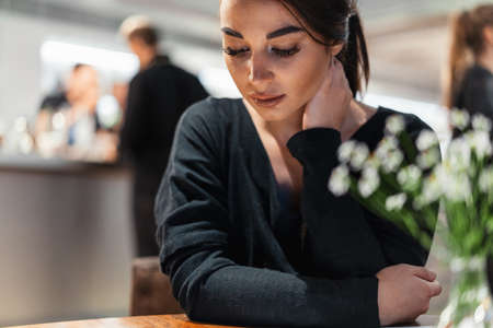 Young beautiful woman looking at menu deciding what to order in modern cafe at date.の写真素材