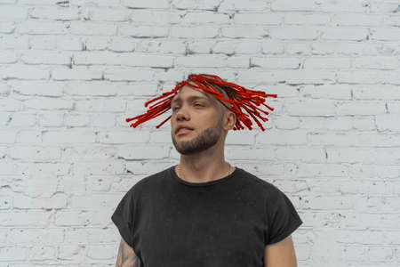 Young attractive man with red dreadlocks shaking his hair.