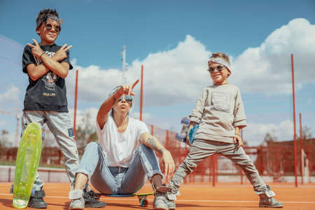 Young mum sitting with her sons at playground. Happy family concept.の写真素材