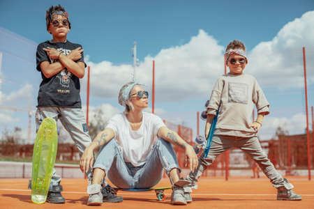 Young mum sitting with her sons at playground. Happy family concept.の写真素材