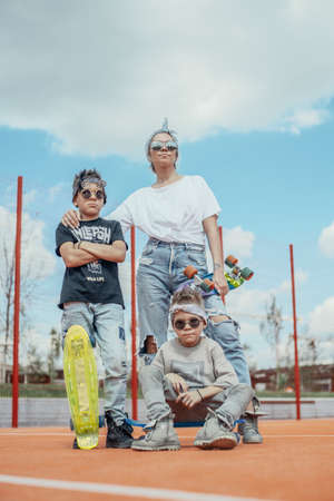 Young woman standing with her sons at playground. Happy family concept.の写真素材