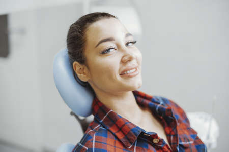 Close up of client smiling while waiting for a stomatologist at dental office.の写真素材