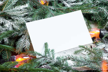 Blank envelope on christmas tree branches, new year decoration and garland.
