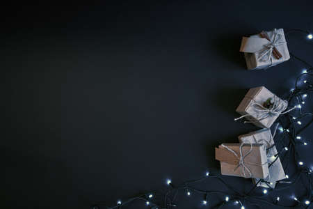 Gift boxes and garland on dark background. New year celebration concept.の写真素材
