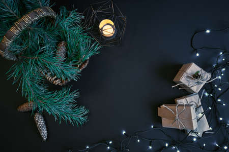 Gift boxes, garland and basket with christmas tree branches on dark background.の写真素材