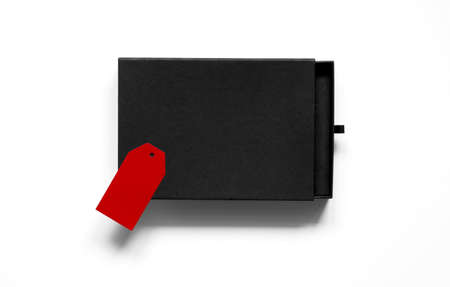 Flatlay of black blank cardboard box with red label on white background. Concept of surprise or sale time. Empty space. Blank box.の写真素材