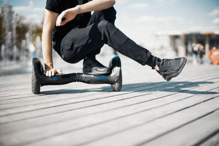 Man riding hoverboard in the park. Close Up of Dual Wheel Self Balancing Electric Skateboard. electrical scooter outdoors. Gyroscooter.の写真素材