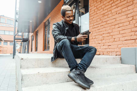 Close up of dark-skinned man looking at mobile phone screen.の写真素材