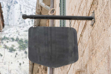 Close up of blank black outdoor banner on ancient wall in European town. Copy spaceの写真素材