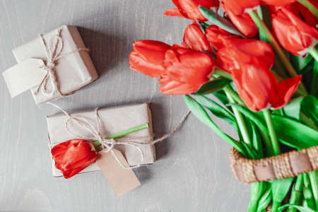 Flatlay of tullips and present wrapped in craft paper Summer or spring time. International women day. Copy space. Empty space.の写真素材
