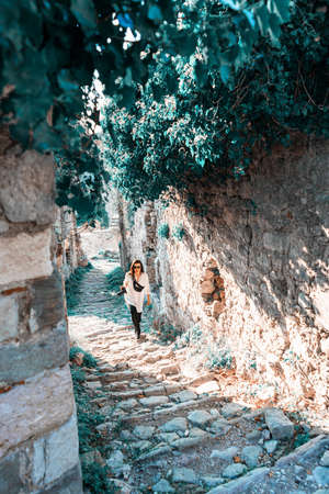 Young woman going for a walk on ancient ruins in Europe and making photos. Traveler and blogger.の写真素材