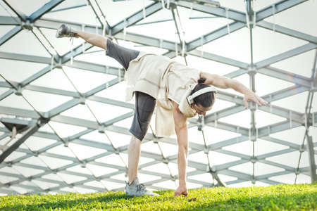 Attractive athletic man practicing yoga and warming up outdoorsの写真素材