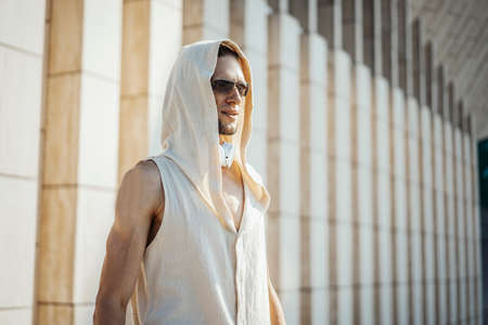 Attractive athletic man practicing yoga with maces outdoors in modern park.の写真素材