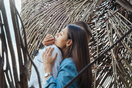 Couple of young beautiful man and woman hugging outdoors at sunny summer day at wooden background at countryside.の写真素材