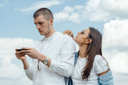 Couple of young beautiful man and woman hugging outdoors at sunny summer day at beautiful landscape background at countryside.の写真素材