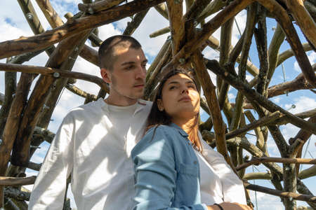 Couple of young beautiful man and woman together outdoors in sunny summer day at wooden background at countryside.の写真素材