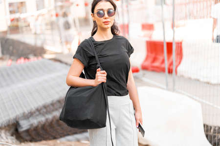 Young attractive woman in black blank t-shirt outdoors. Empty space. Copy space.の写真素材