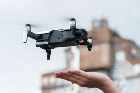 Close up of drone quadcopter inflight. Cityscape background. remote controlled wireless quadcopter drone with video and photo camera for aerial photography flying in the air outdoorsの写真素材