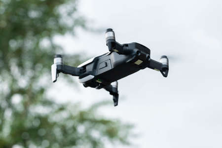 Close up of drone quadcopter inflight. Cityscape background. remote controlled wireless quadcopter drone with video and photo camera for aerial photography flying in the air outdoorsの写真素材