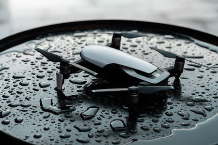 Close up of drone quadcopter on black wet backround. remote controlled wireless quadcopter drone with video and photo camera for aerial photographyの写真素材