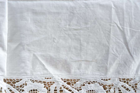 Close up of white rustic cotton table cloth on wooden table.の写真素材