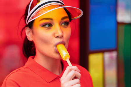 Close up of Young sexy brunette woman eating ice cream at sunny hot day.の写真素材