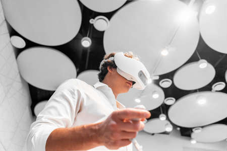 Man wearing virtual reality goggles in modern bright co-working office. the VR experience.