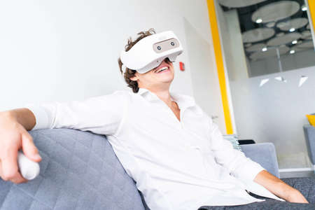 Man wearing virtual reality goggles in modern bright co-working office. the VR experience.の写真素材